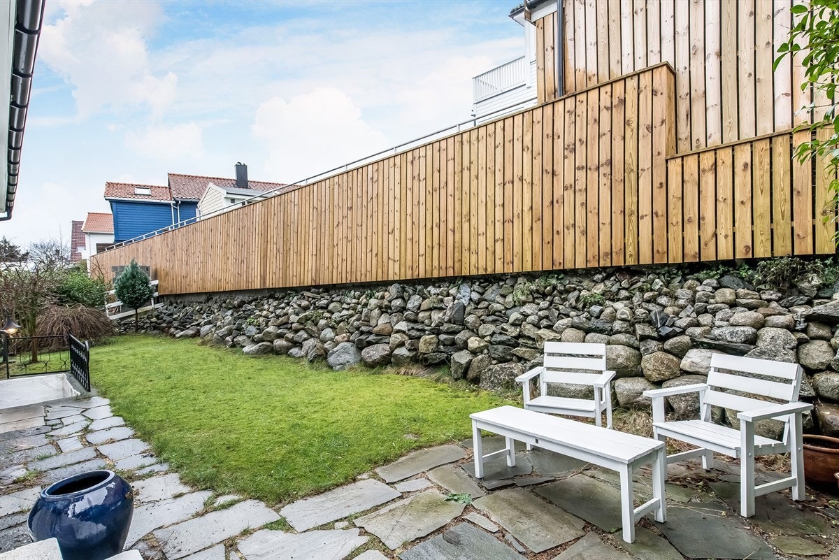 Koselig hage med litt plen og steinheller. Galleribilde