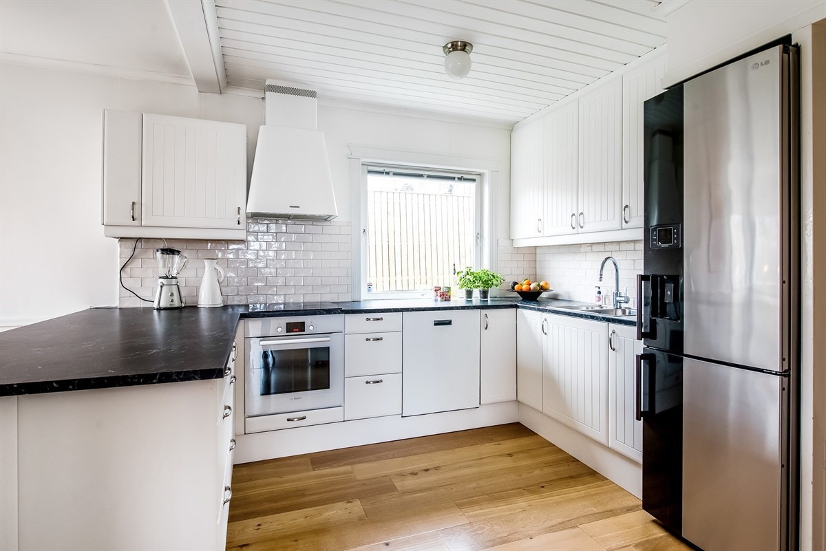 Et innholdsrikt kjøkken med mye skapplass. Galleribilde