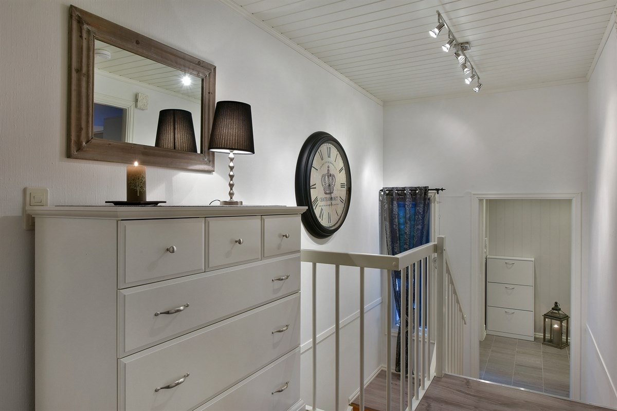 Entreen er lys og innbydende med flislagt gulv, gulvvarme, downlights og lysegrå veggflater. Galleribilde