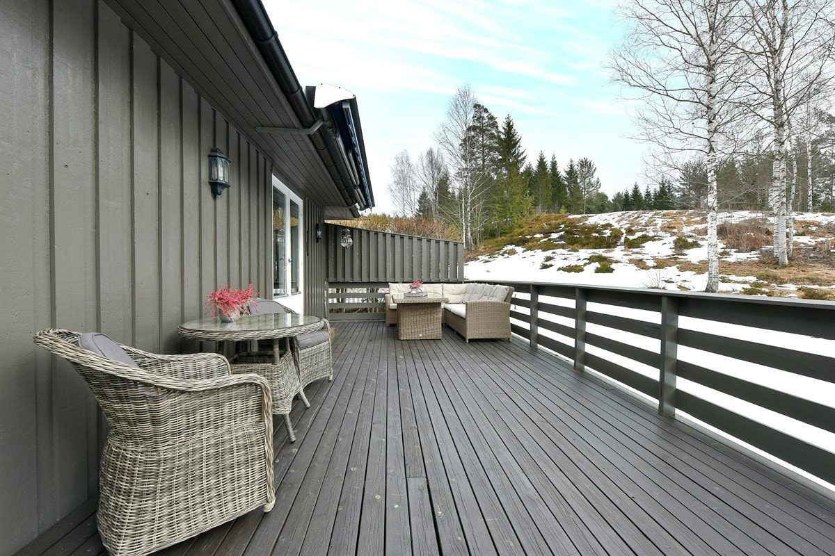 Terrassen har levegg på én side, og ellers utsyn rett mot friområdet som omkranser tomta. Galleribilde