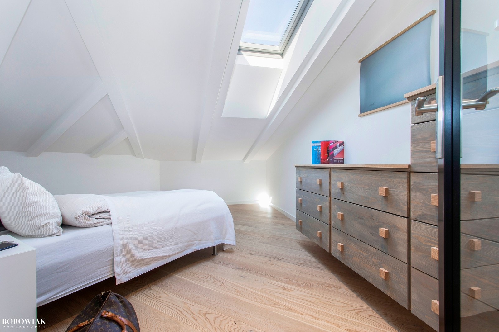 Arealeffektivt soverom med Velux takvindu, glassfelter og sort Scanflex glassdør Galleribilde