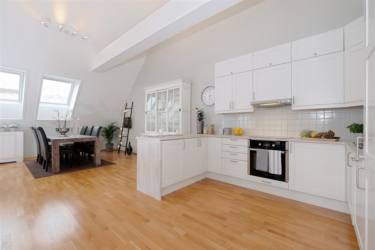 Lys og pen kjøkkeninnredning fra Marbodal med hvitlakkerte, profilerte skapfronter. Galleribilde