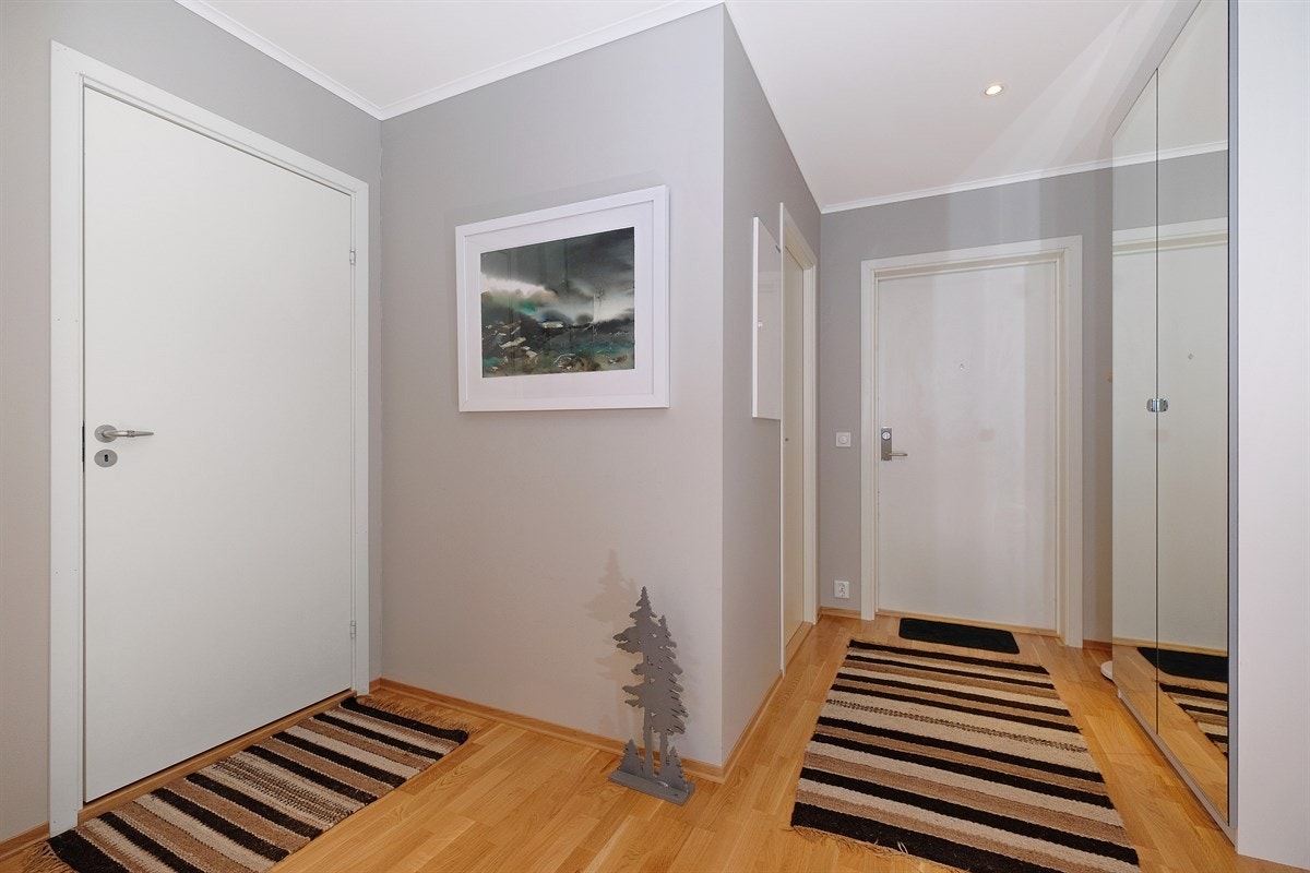 Romslig entré med skyvedørsgarderobe og praktisk garderobeskap med speildører. Galleribilde