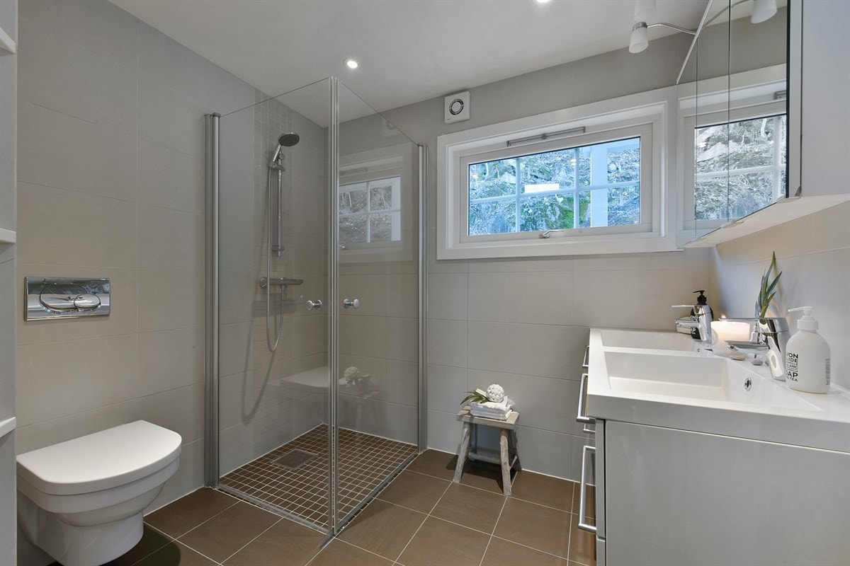 Badet som tilhørende hoveddelen er delikat og har lekre detaljer som flere åpne, fastmonterte vegghyller. Galleribilde