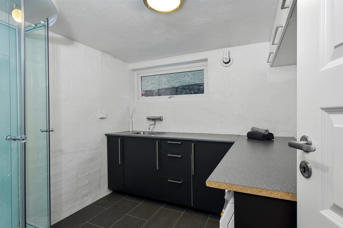 Badet/vaskerom i kjelleren har opplegg for vaskemaskin og tørketrommel under benk. Galleribilde