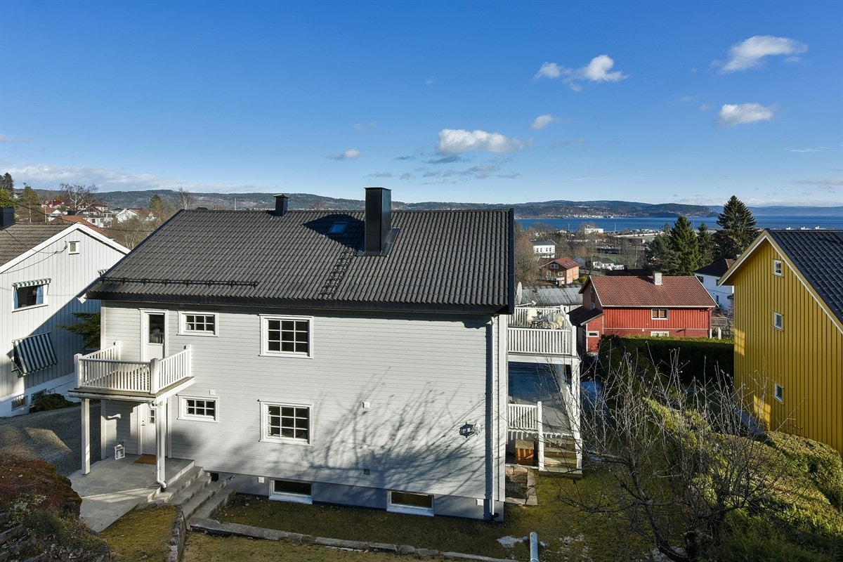 Gårdsplassen er gruset og har parkeringsplass for flere biler. Galleribilde