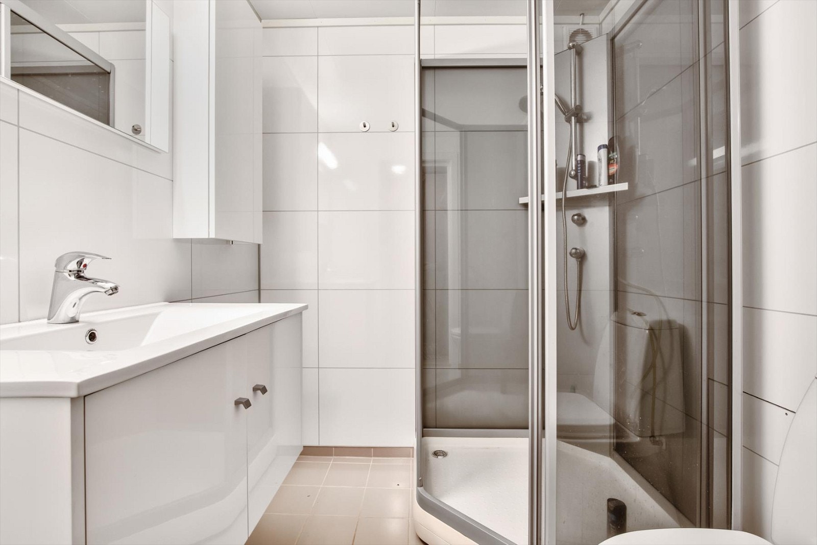 Bad i u.etg renovert i 2014, med fliser på gulv og våtromsplater på vegg. Hvit innredning med nedfelt vask , veggskap og speil. Ellers innredet med dusjkabinett og wc. Galleribilde