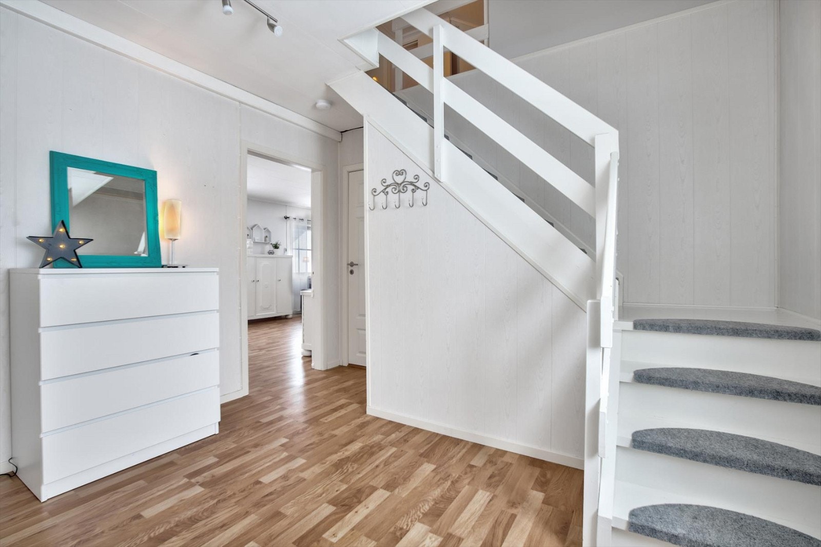 Gang i lyse overflater med trapp til loft, samt adkomst til stue/kjøkken, bad og soverom i hovedetasjen. Galleribilde