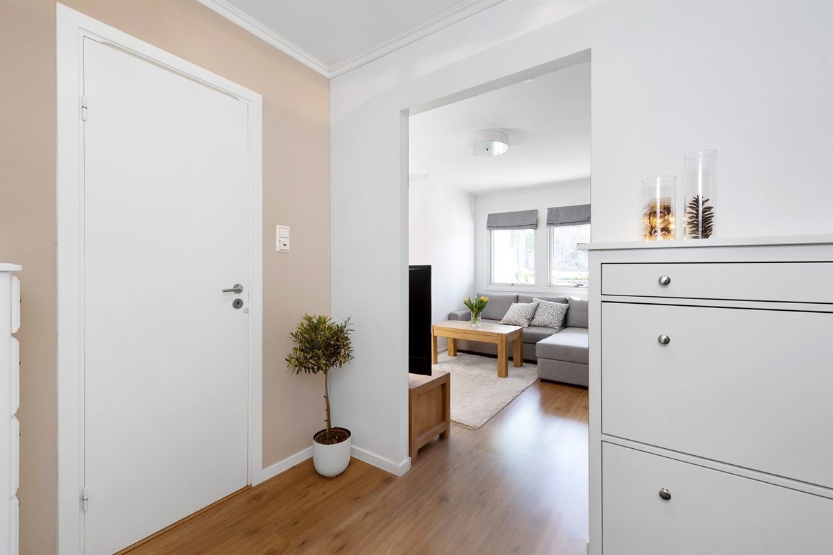 Entreen gir et godt førsteinntrykk av leiligheten og er tidsriktig innredet med laminatgulv, vegger malt i delikate nyanser, hvitmalt himling, og dørcalling. Galleribilde