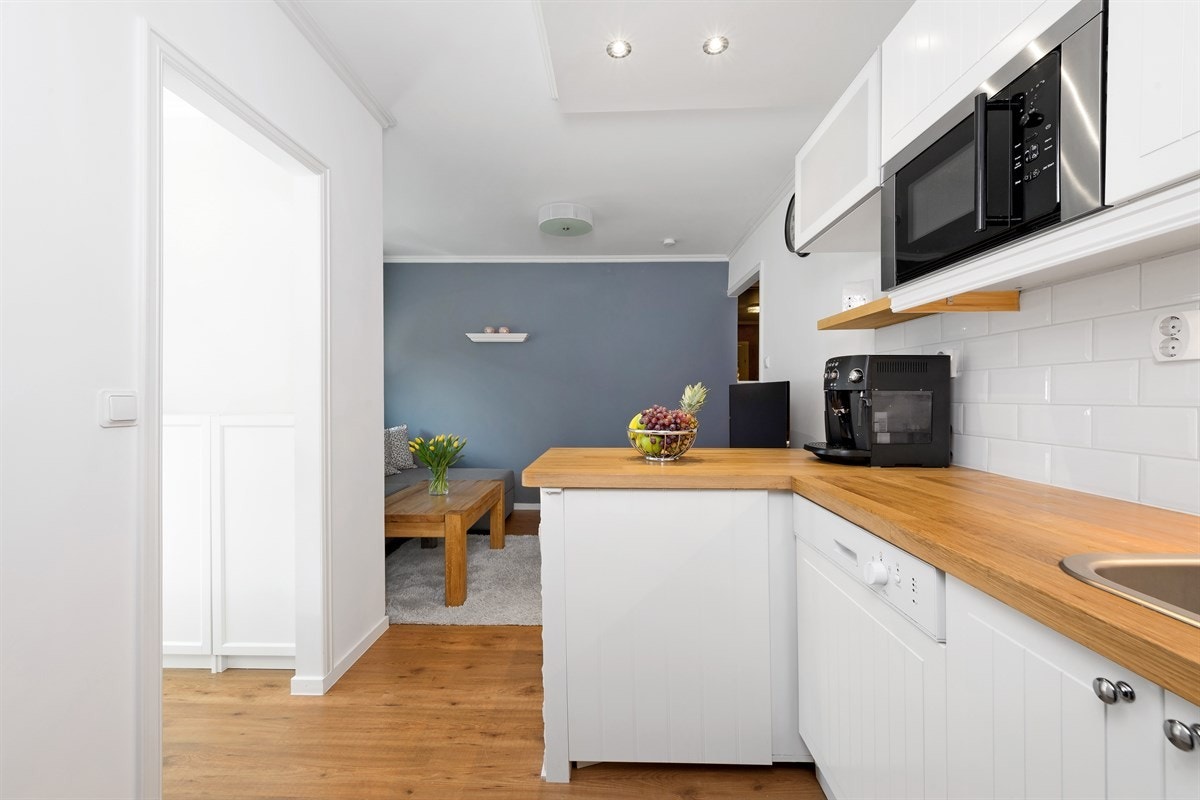 Innredningen fra Ikea har hvite rillefronter, skyllekum nedfelt i benkeplate av heltre eik, samt hvite metrofliser og downlights over benk. Galleribilde