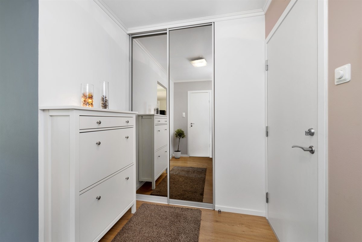 Entreen har plassbygd skyvedørsgarderobe med speilfronter som gir godt med oppbevaringsplass. Galleribilde