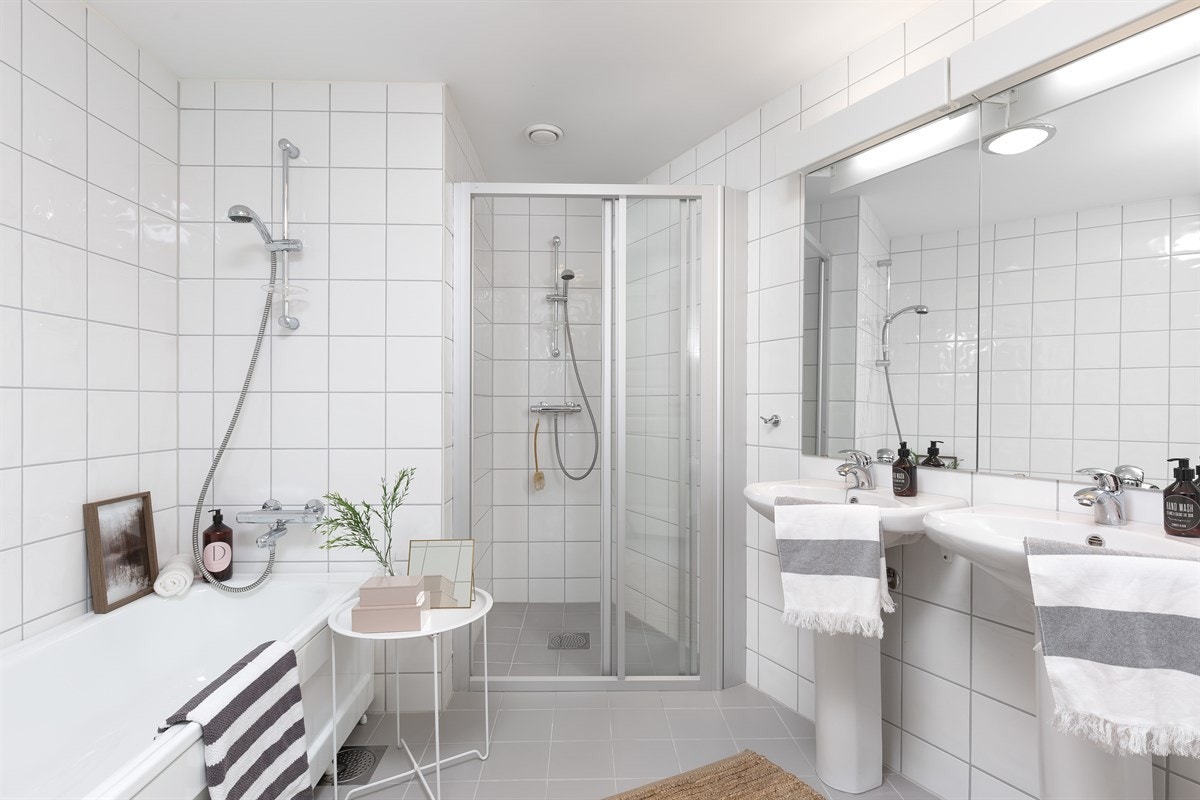 Hovedbadet er flislagt med varmekabler i gulv og downlights i himling. Fremstår som moderne og med fin og tidsmessig innredning Galleribilde