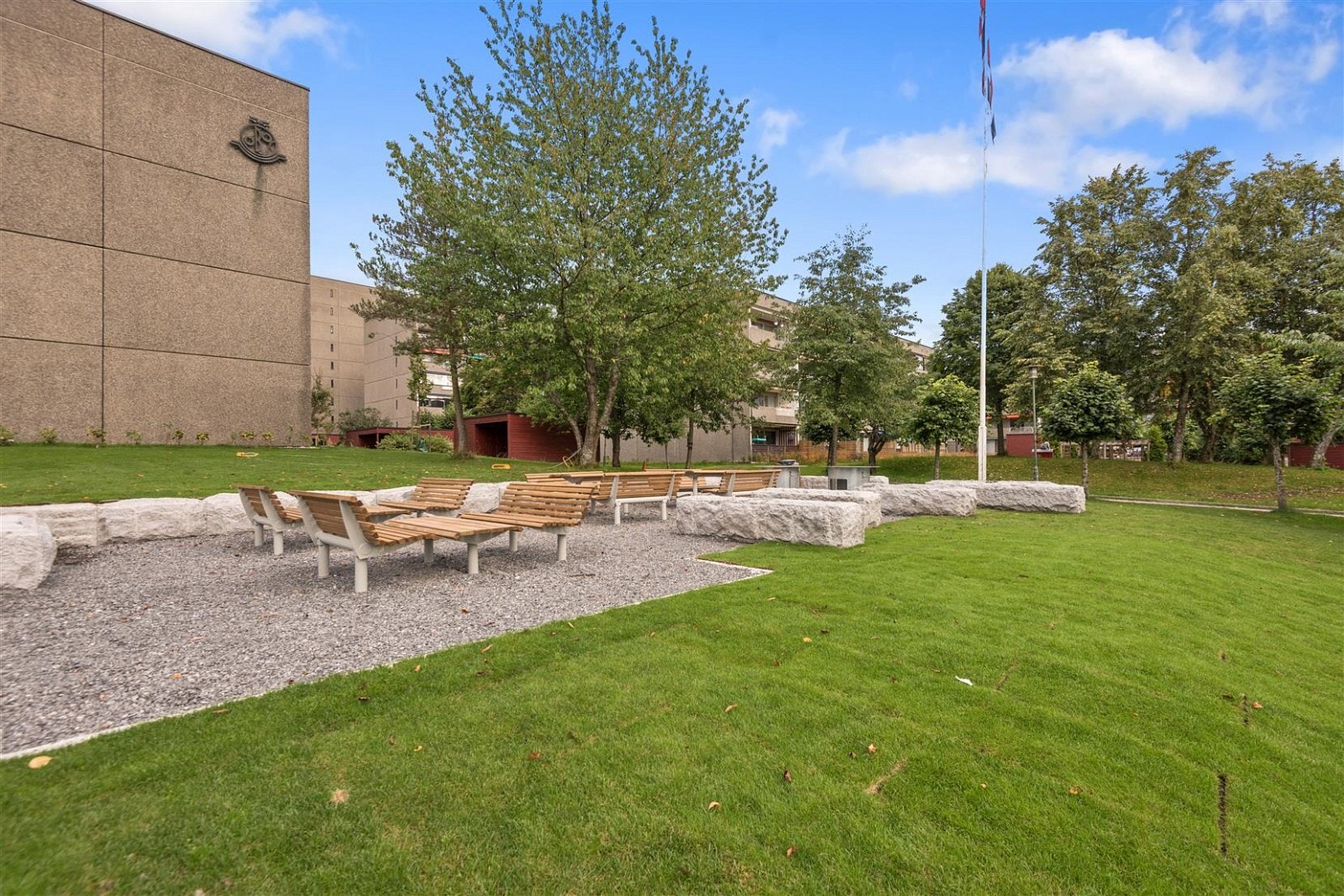 Opparbeidede plasser med sittegrupper, plen og lekeapparater. Galleribilde