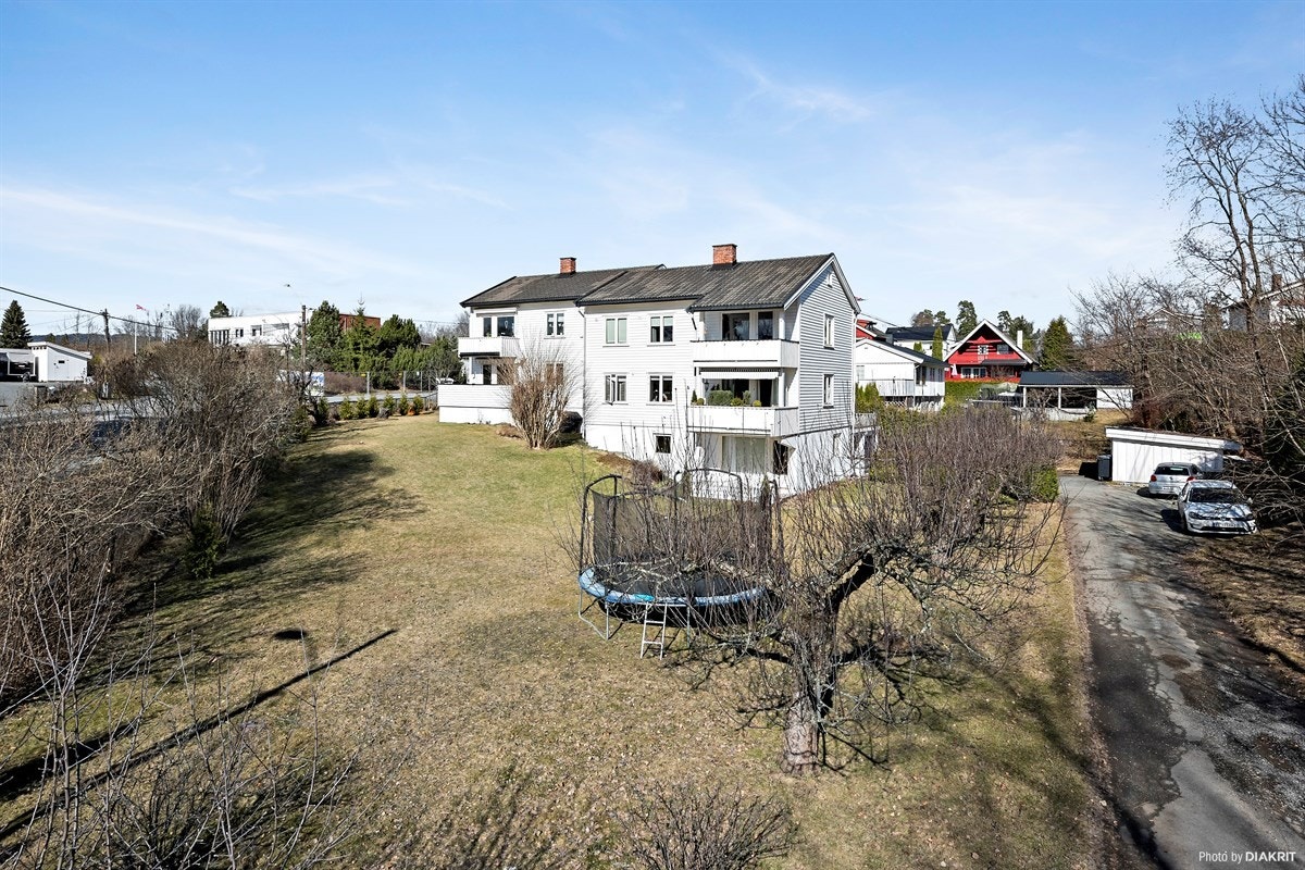 Stor, frodig hage som brukes mye av alle som bor i boligen - flere utegrupper, grill og trampoline Galleribilde