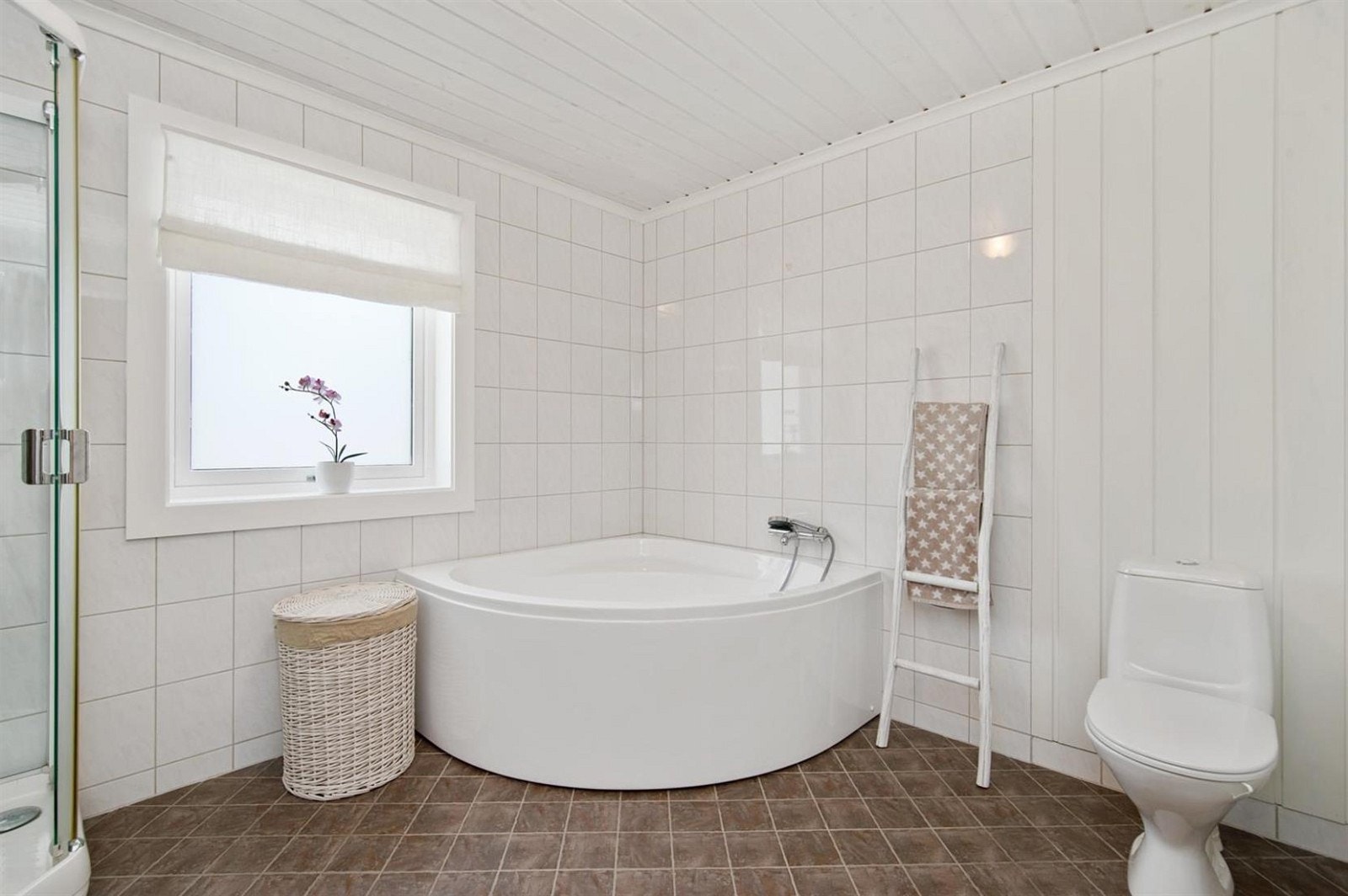 På badet er det flis på gulv med varmekabler. Flis og panel på veggene. Dusjkabinett, badekar, wc og servant med innredning.
Det er separat vaskerom. Galleribilde