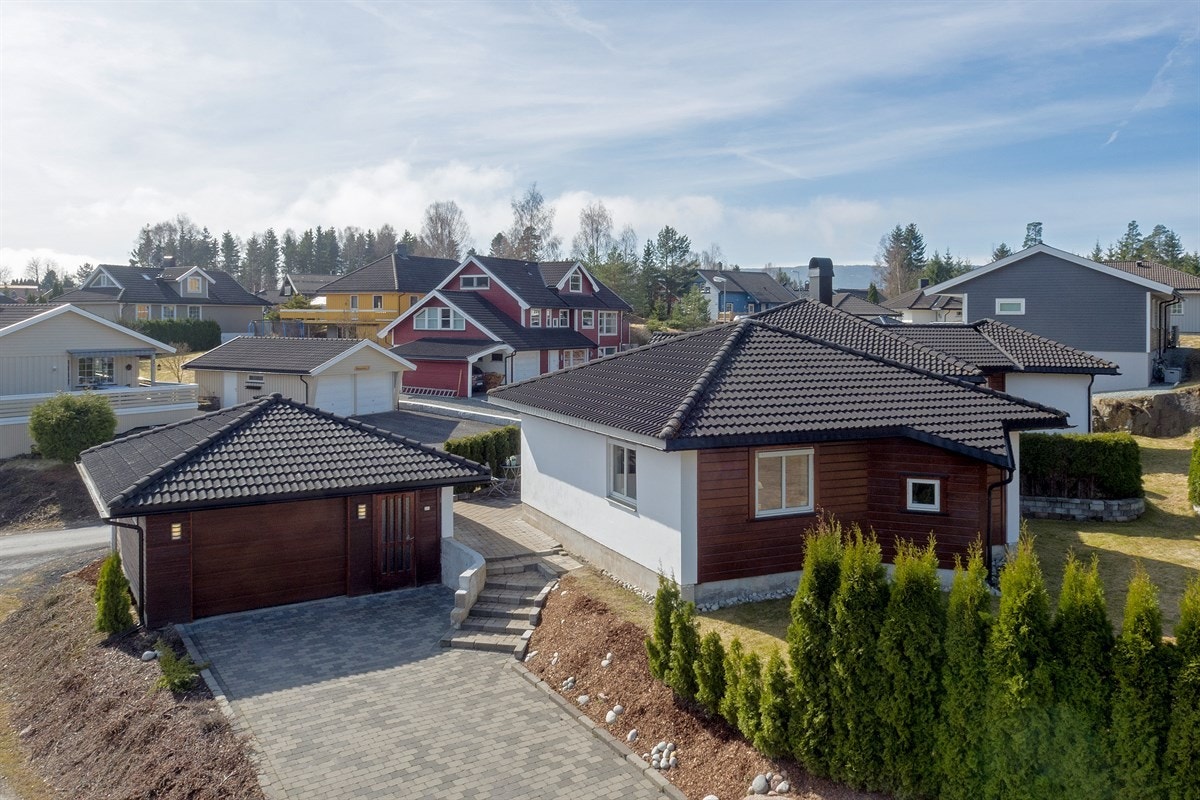 Det er parkering i en stor enkelgarasje med elektrisk port og biloppstillingsplasser på egen tomt. Galleribilde