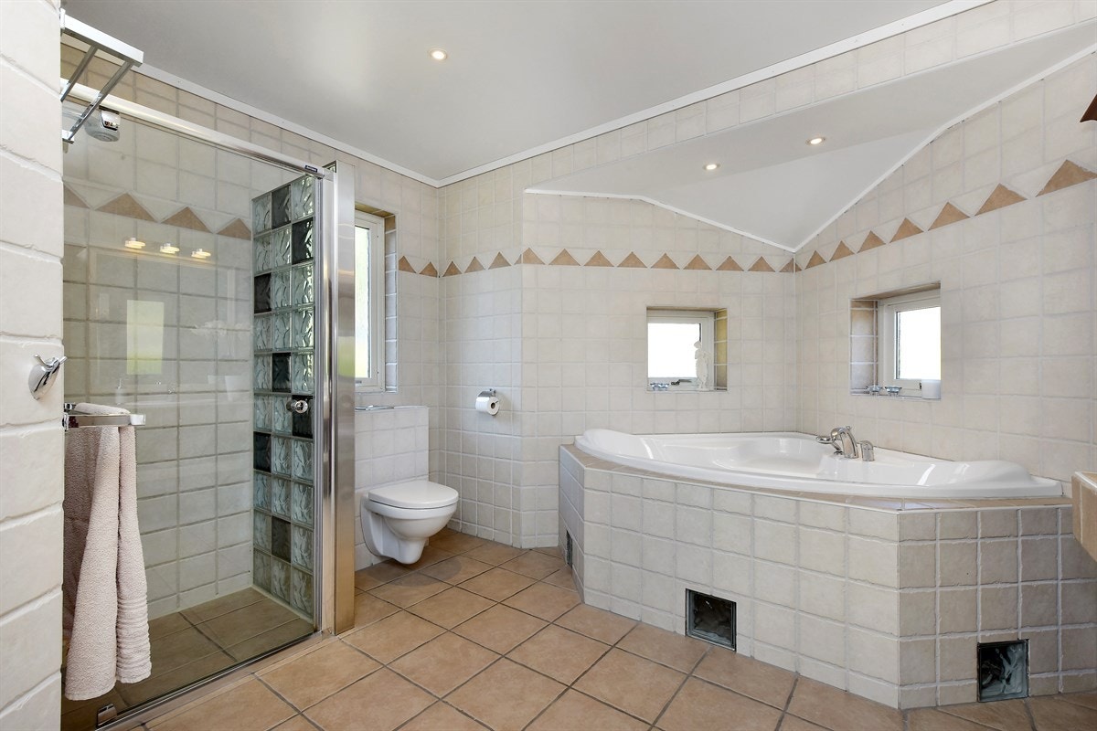 Dette badet er bygd med tanke på ekstra velvære og inneholder blant annet et stort, innfliset hjørnebadekar. Galleribilde