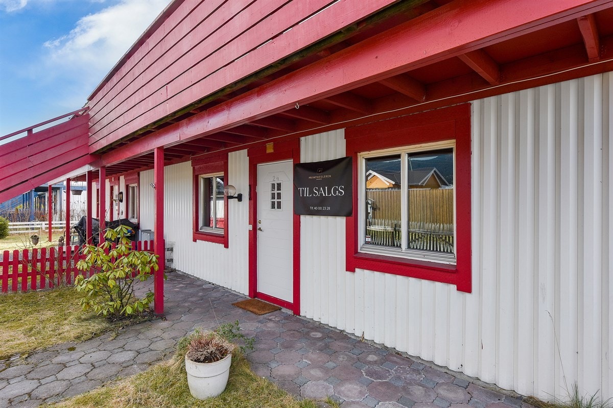 Fra et steinbelagt og pent uteområde er det adkomst til boligens entré. Galleribilde
