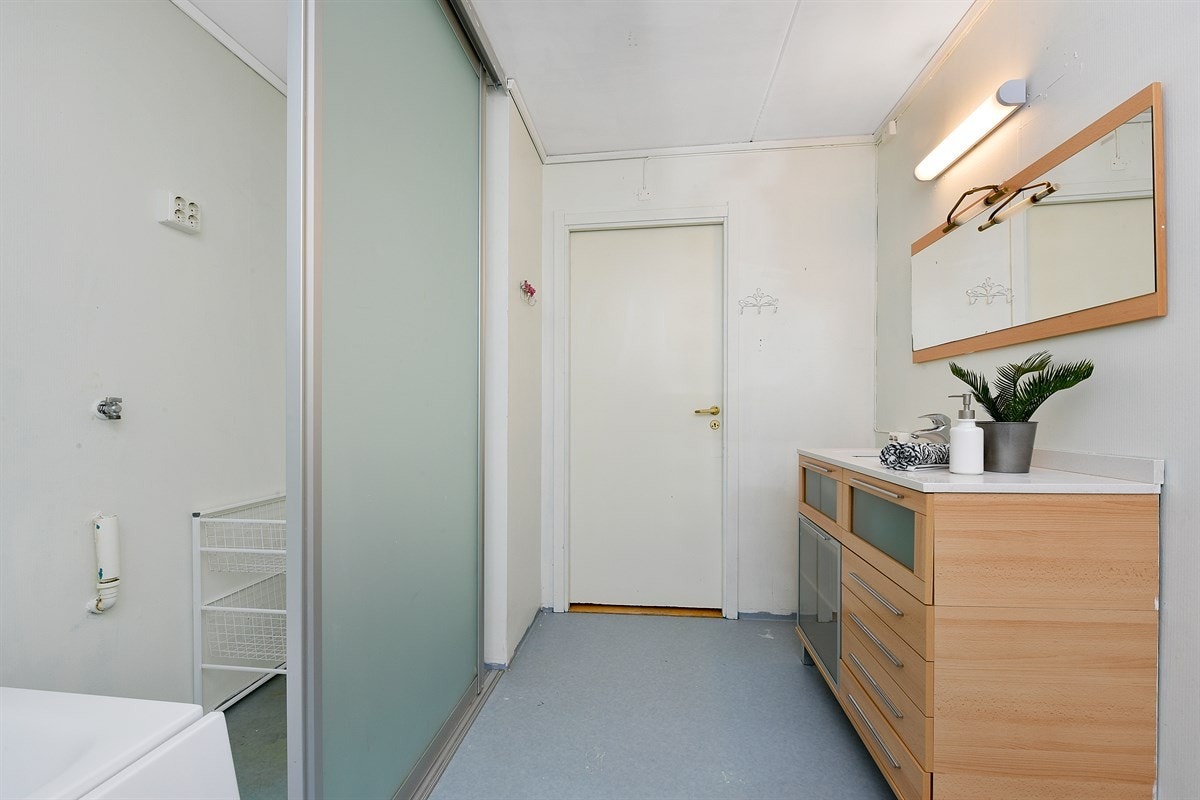 Badekar og opplegget for vaskemaskin er praktisk plassert bak skyvedører, noe som gir et ryddig inntrykk. Galleribilde