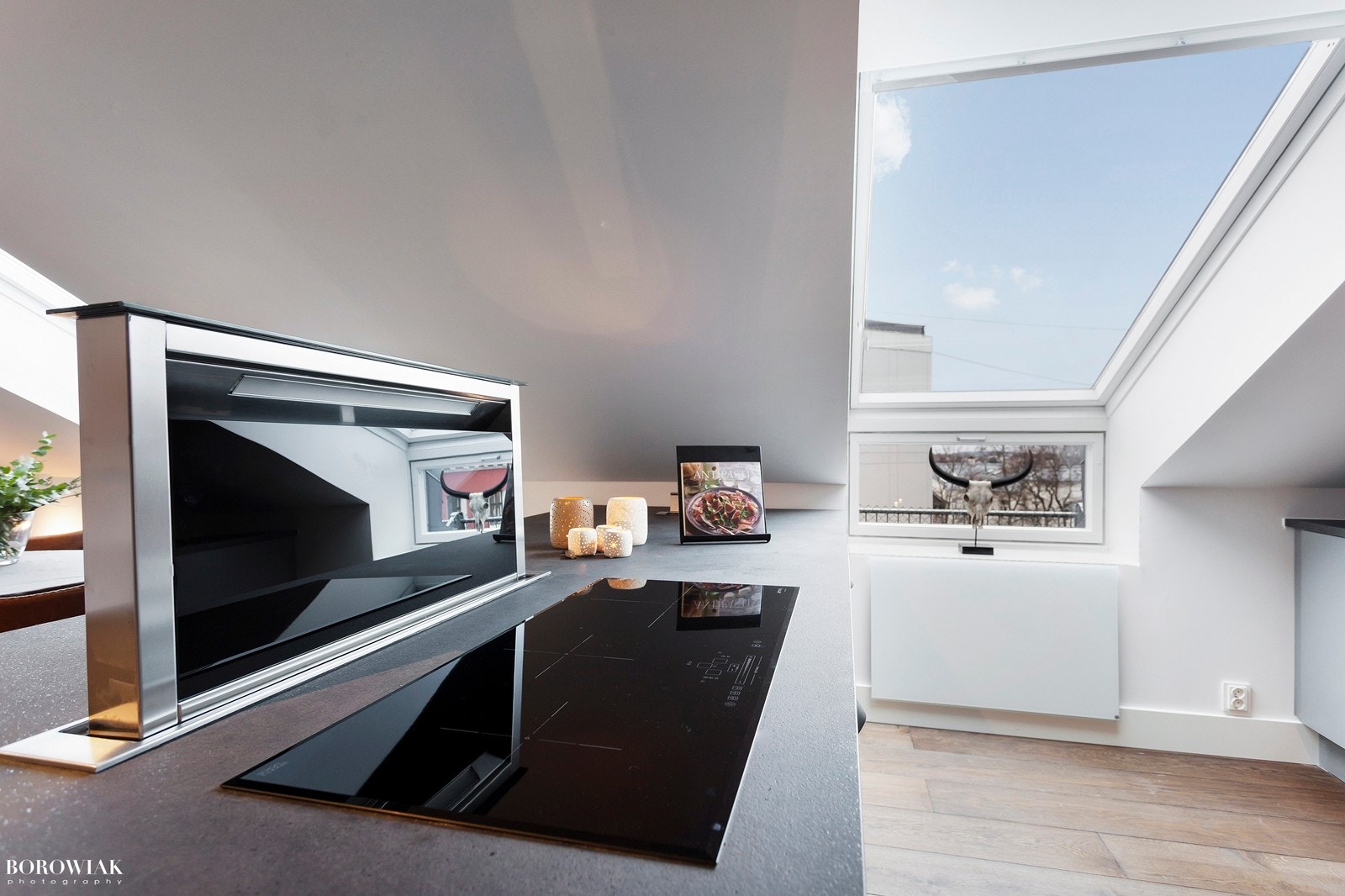 Lekkert kjøkken fra HTH med kjøkkenøy og heve-senke ventilator mot spisestuen Galleribilde