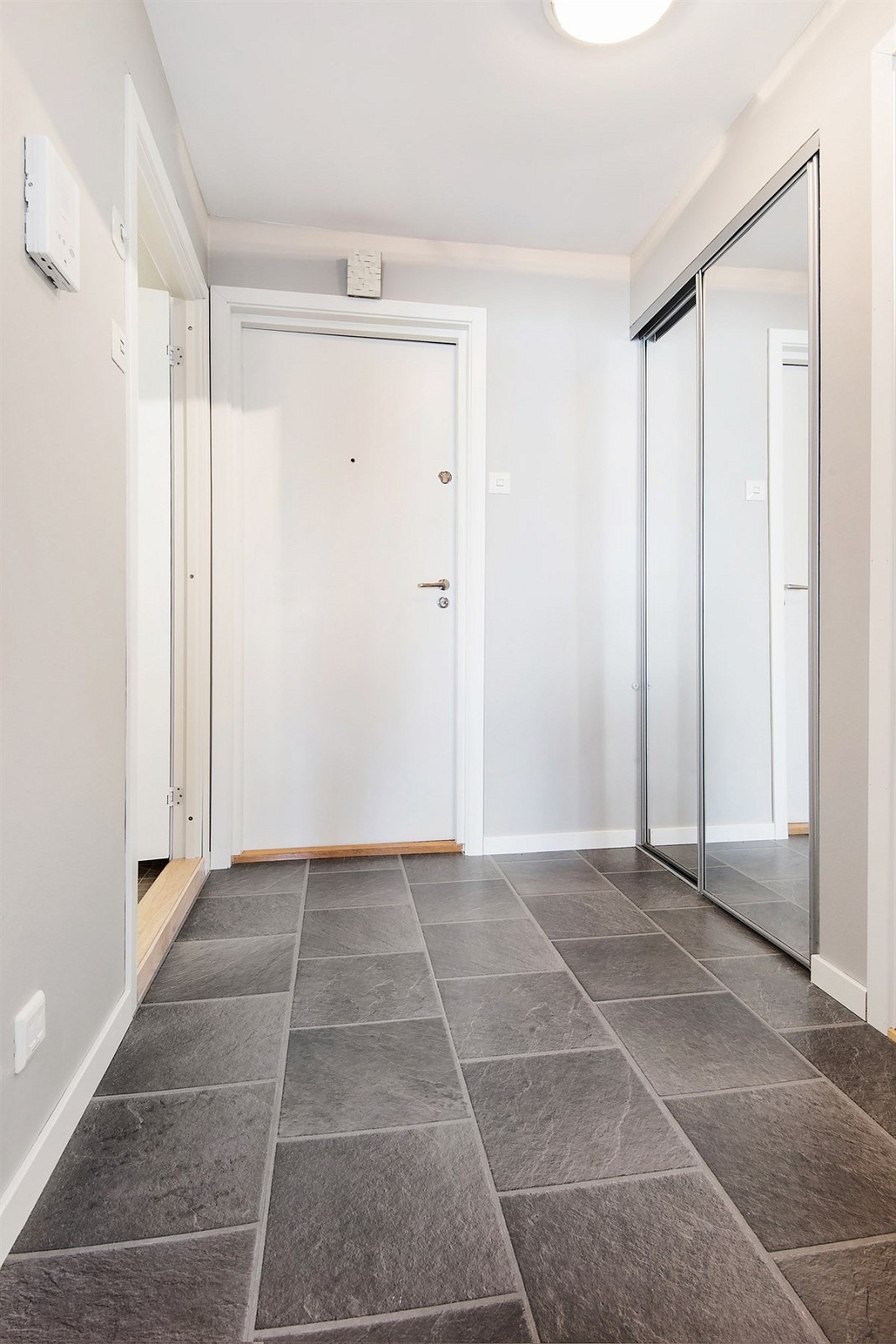 Lys og innbydende entré med fliser som gir et godt førsteinntrykk av leiligheten. Galleribilde
