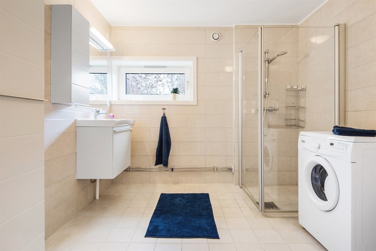 Pent flislagt bad fra 2010 med dusjhjørne og opplegg for vaskemaskin. Galleribilde