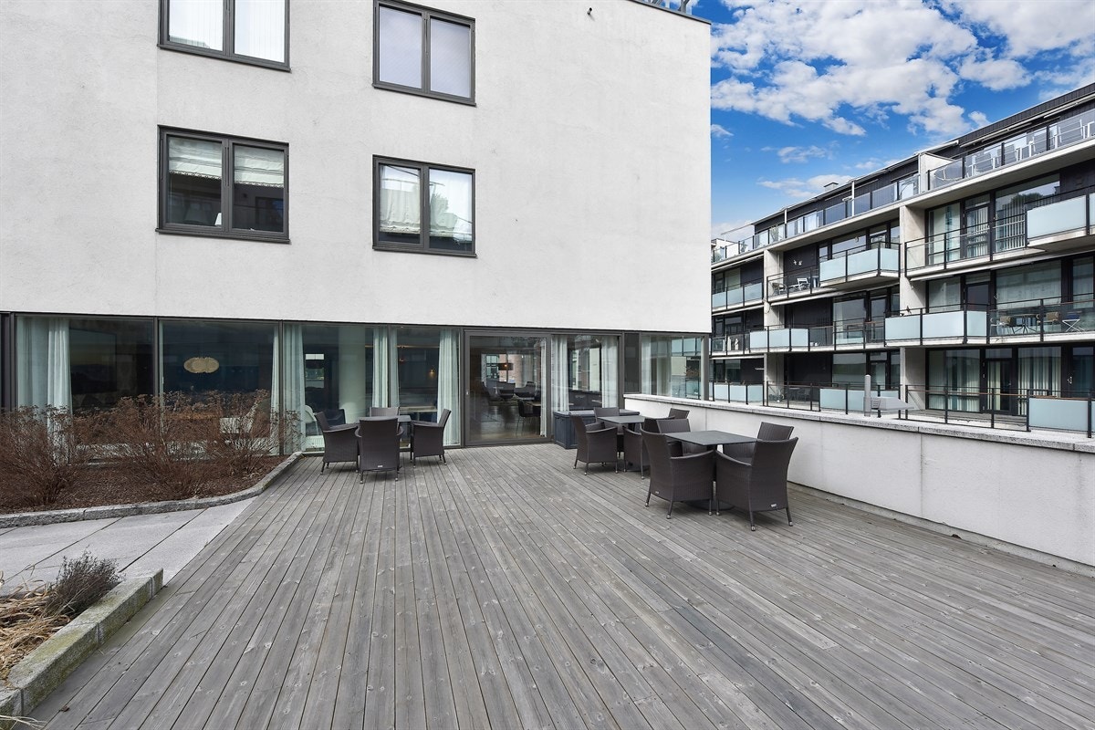 Det er etablert en platting med flere sittegrupper for hyggelige sosiale sammenkomster samt inngang til serviceområder. Galleribilde