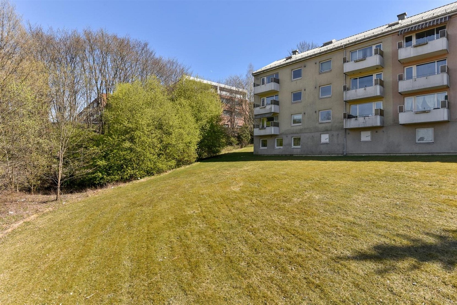 Bygning ligger på en høyde med fin utsikt. Fellesområdene er pent opparbeidet med plenareal, prydbusker, trær og asfalterte adkomstveier. Galleribilde