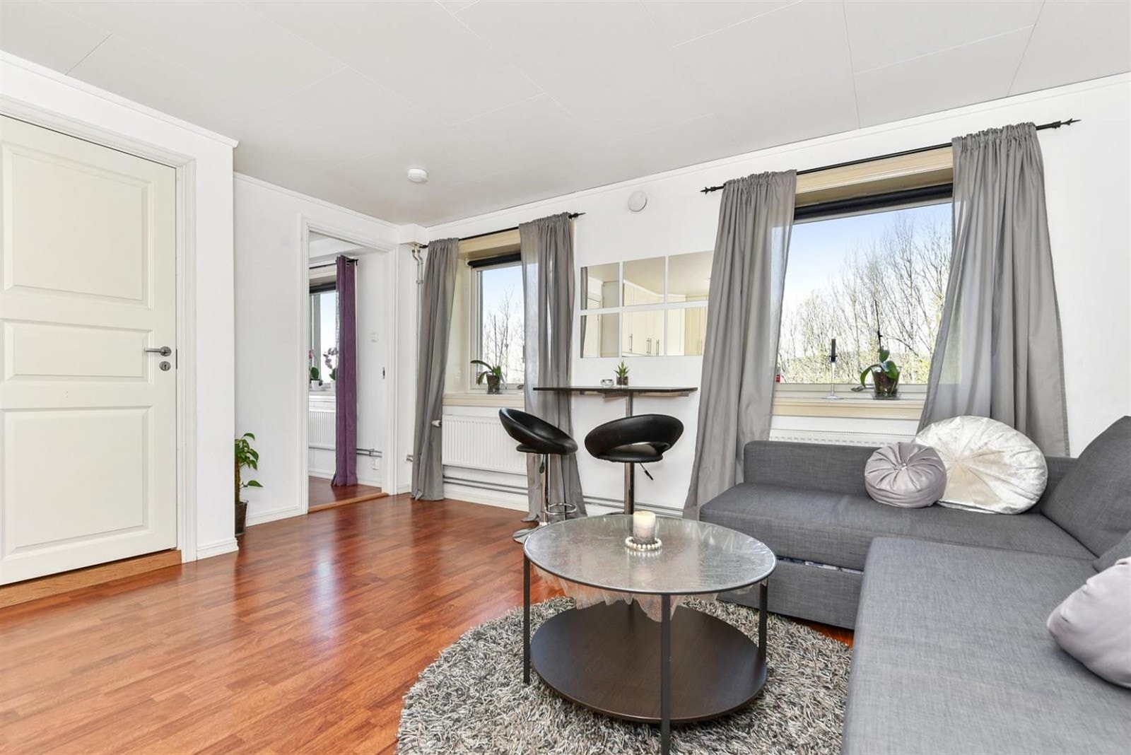 Lys og trivelig stue med naturlige møbleringssoner. Galleribilde