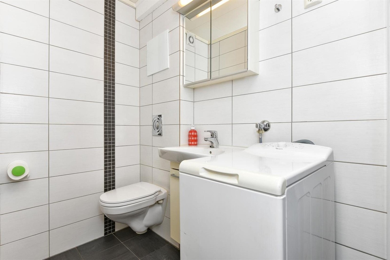 Innredningen består av servant nedfelt i skap og speilskap med belysning. Videre er det vegghengt toalett, dusjhjørne med to skjermvegger i glass og opplegg for vaskemaskin. Badet har elektrisk avtrekk og gulvvarme. Galleribilde