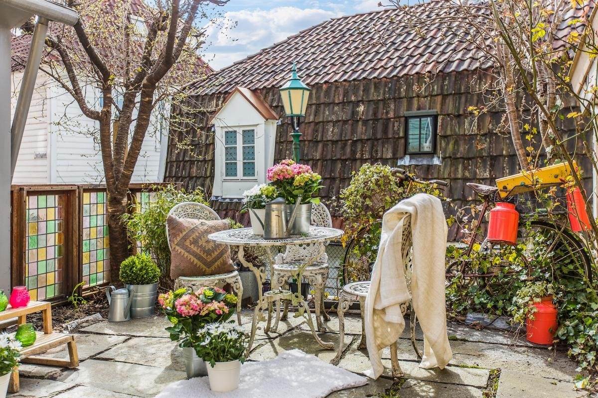 Hagen er hovedsakelig hellelagt, med et tuntre midt på. Galleribilde