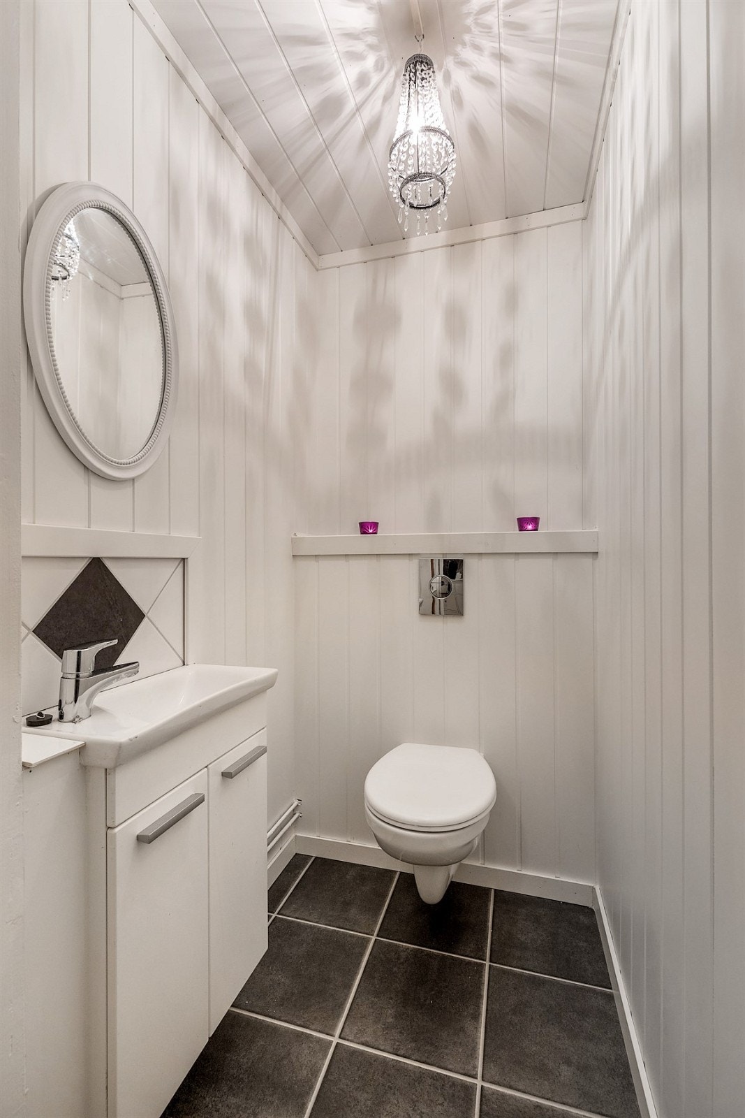Innbydende wc med vegghengt toalett og servant med underskap. Galleribilde
