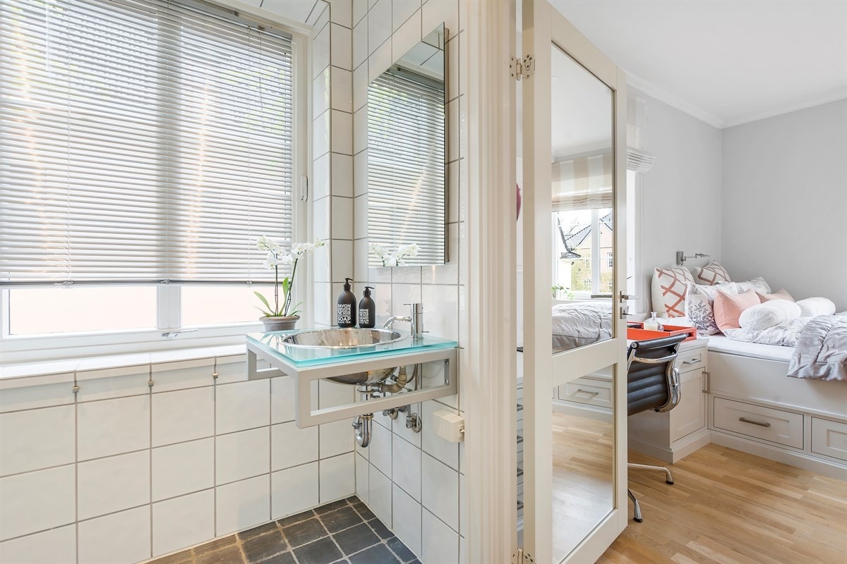 Fra soverommet er det adkomst, via dør med innfelt speil, til et lyst og pent bad Galleribilde