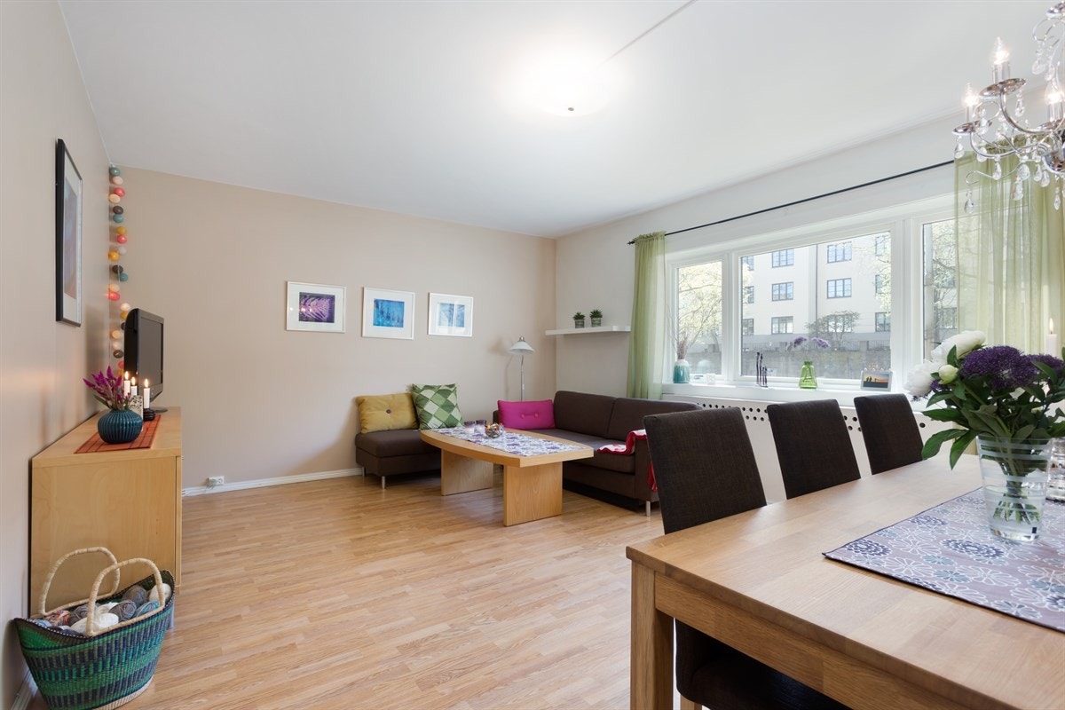 En stor stue med plass til både sofaseksjon og spisebord. Mye naturlig lys gjennom store vindusflater. Galleribilde