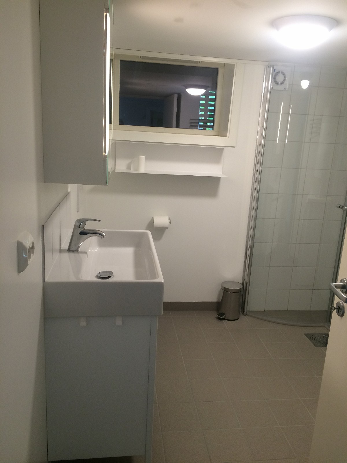 Bad med vask, dusj og vaskemaskin/ tørketrommel. Galleribilde