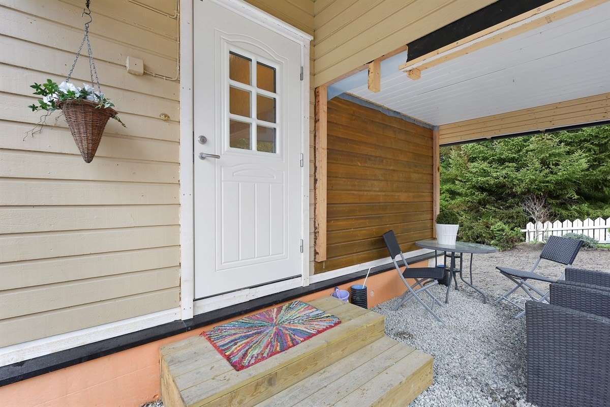 Boligen har et overbygd inngangsparti og glassfelt i ytterdøren. Galleribilde