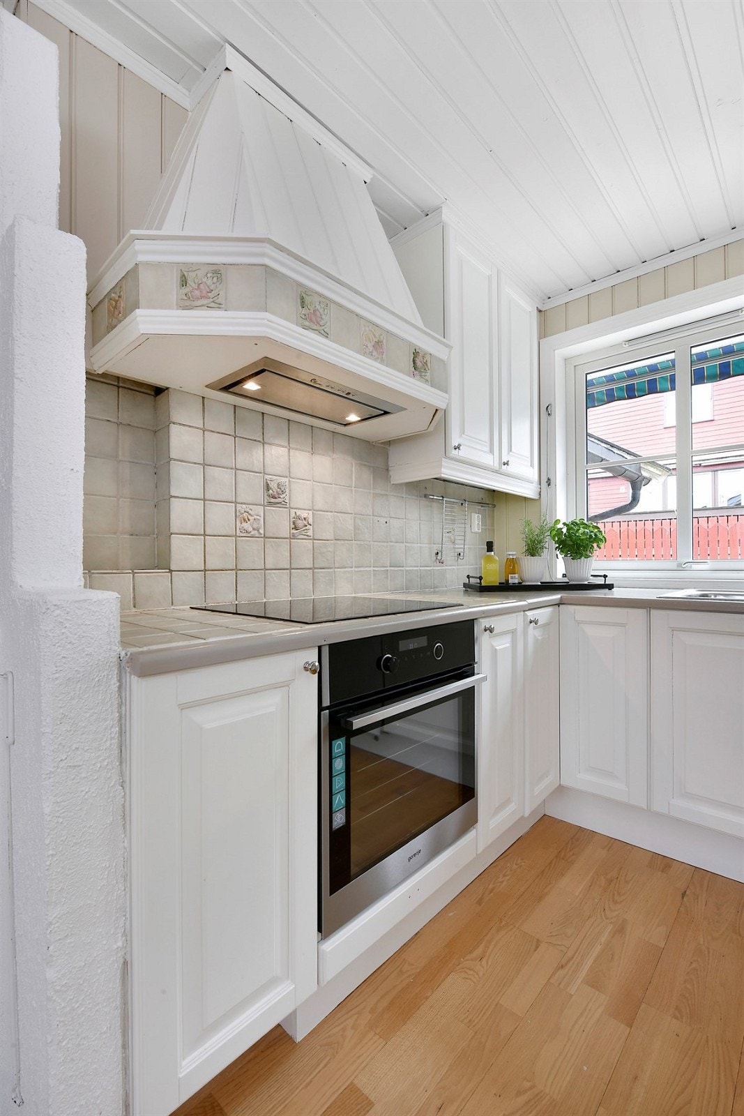 Benkeplaten i laminat har nedfelt dobbel oppvaskkum, mens det rundt koketoppen er flislagt benk. Galleribilde