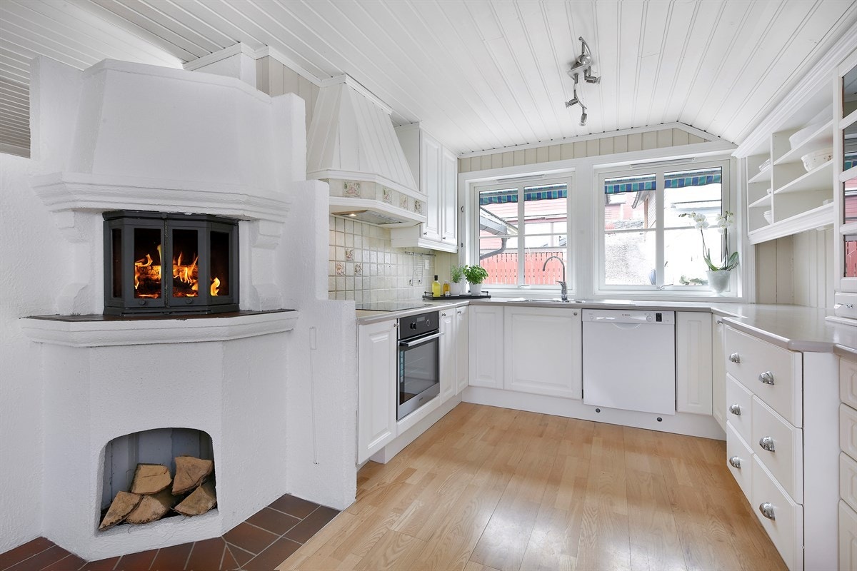 Mellom stuen og kjøkkenet er det en koselig elementpeis med innsats, med egen nisje for oppbevaring av ved. Galleribilde