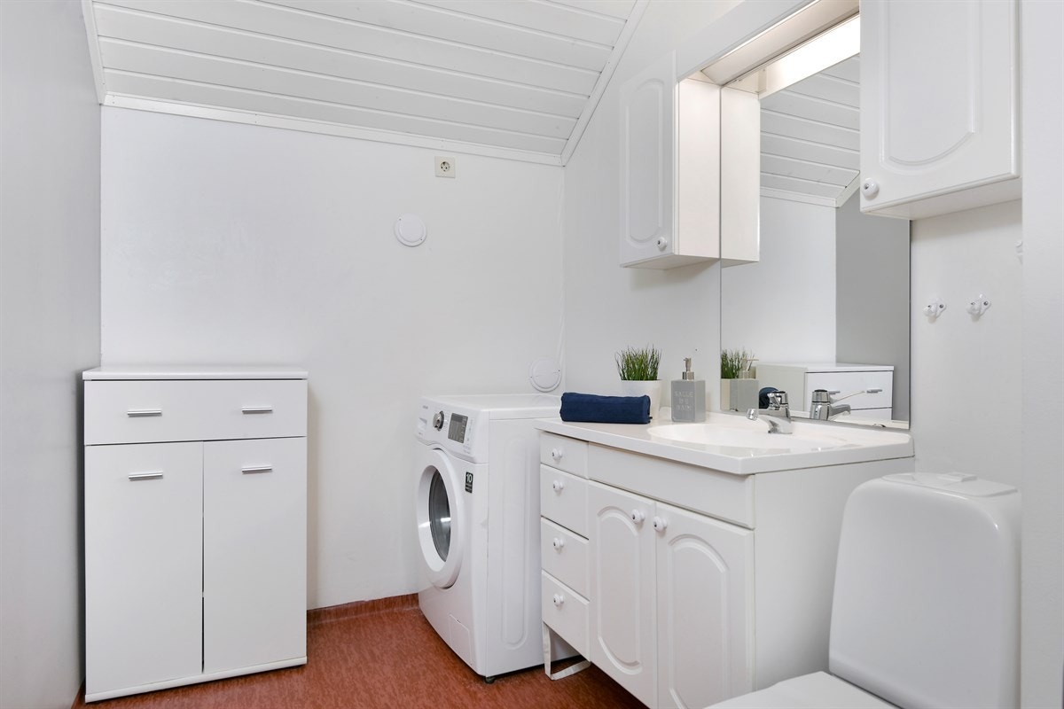 Ved entreen har boligen et kombinert toalett- og vaskerom med opplegg for vaskemaskin. Rommet har gulvbelegg og malte vegger, samt gulvmontert toalett. Galleribilde