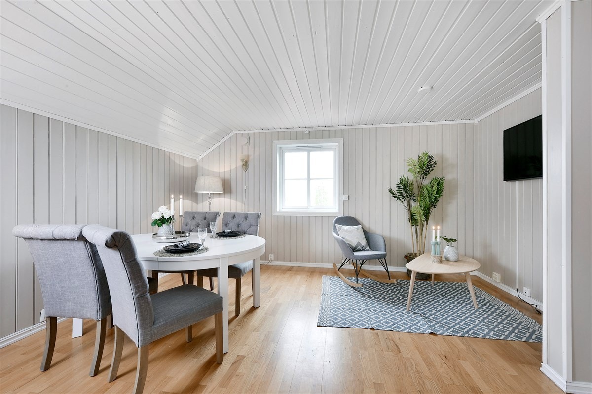 Stuen har parkett på gulv og malte panelplater i tidsriktig farge. Galleribilde