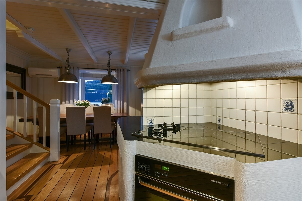 Kokesonen befinner seg i en murt grueløsning med integrert stekeovn, keramisk koketopp, gassbluss og innkledt ventilator. Galleribilde