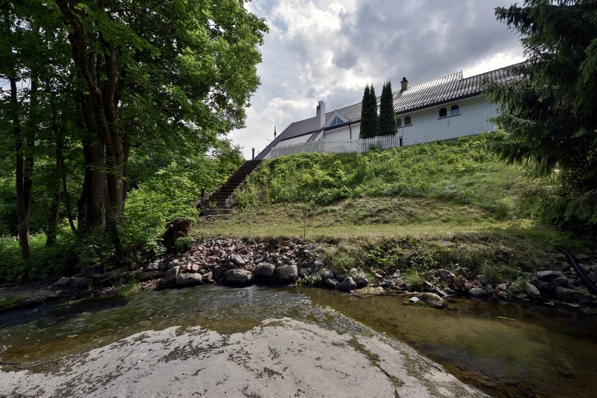 På nedsiden er det trapp fra hagen til en herlig vannkulp med omkringliggende skog. Galleribilde