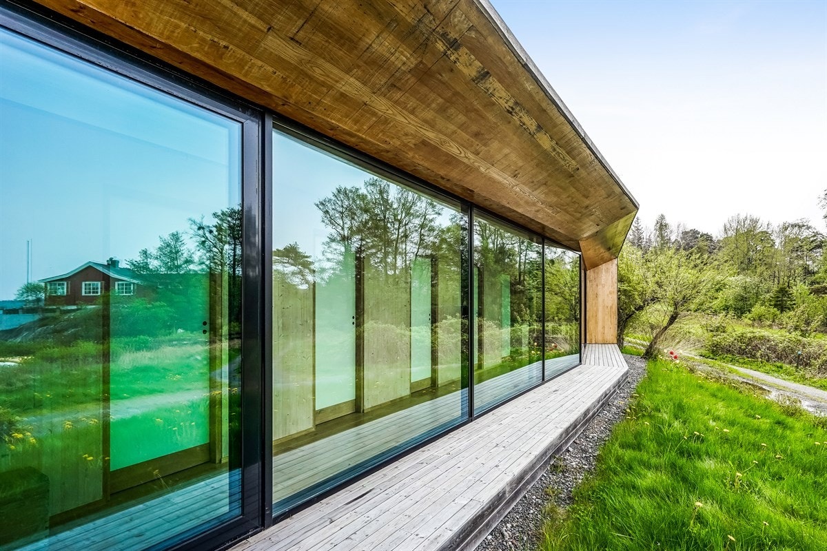 Hele fasaden i 1. etasje mot sjøen består av glassflater fra gulv til tak Galleribilde