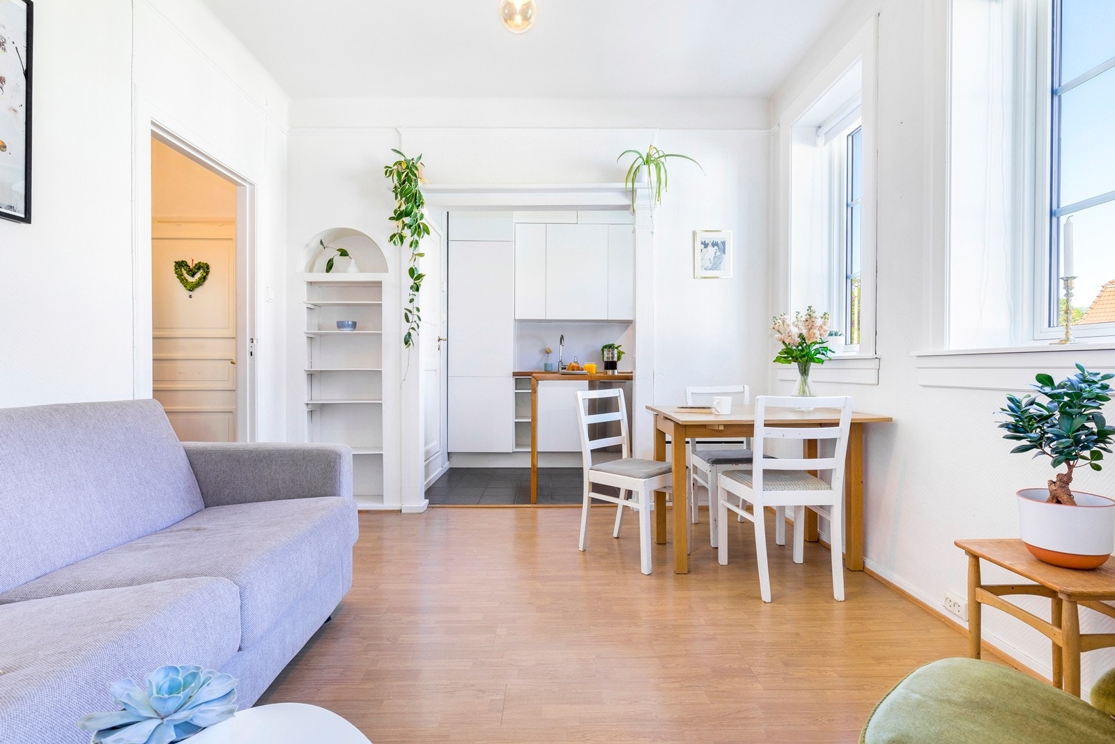 Lys og innbydende stue som preges av generøs takhøyde og store vindusflater som slipper inn godt med lys i leiligheten. Galleribilde