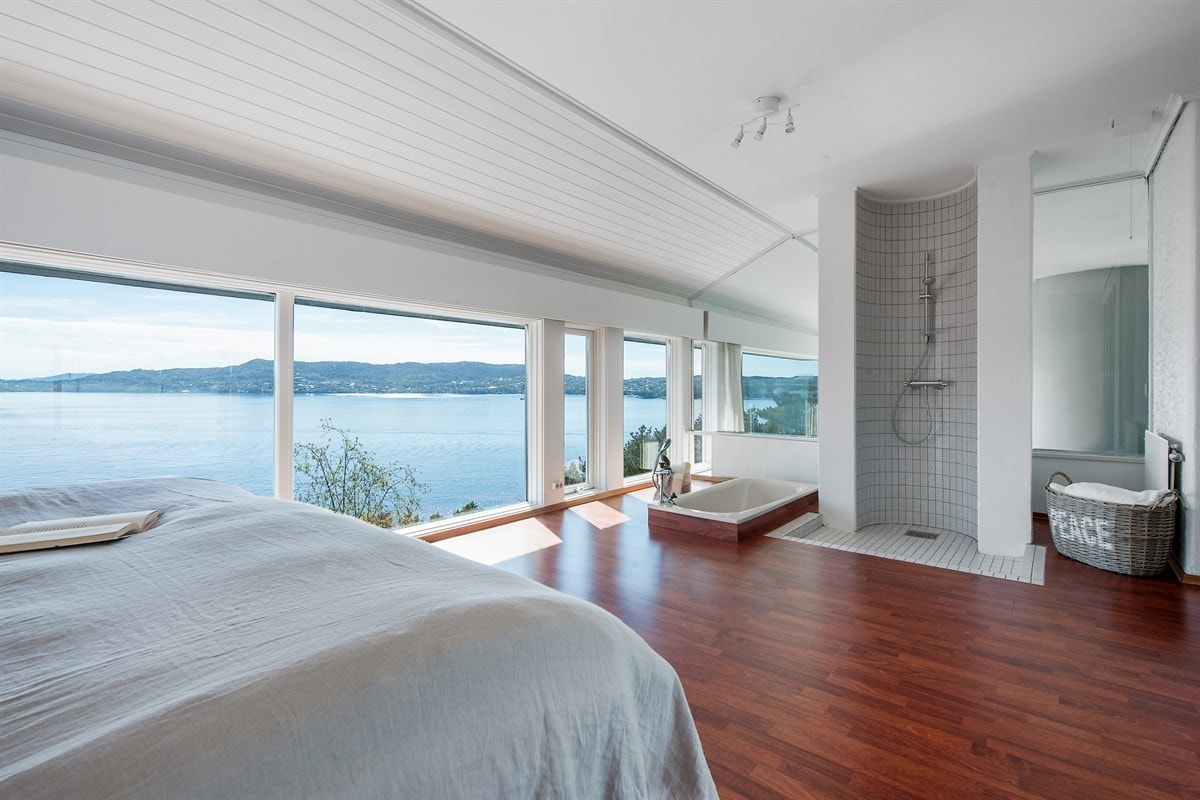 I enden av soverommet har man dusj og badekar. Legg også merke til glassveggen mot stue. Galleribilde