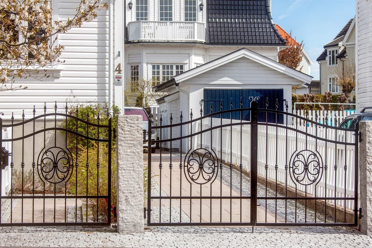 Bak hvitt stakitt og utsmykkede smijernsporter Galleribilde