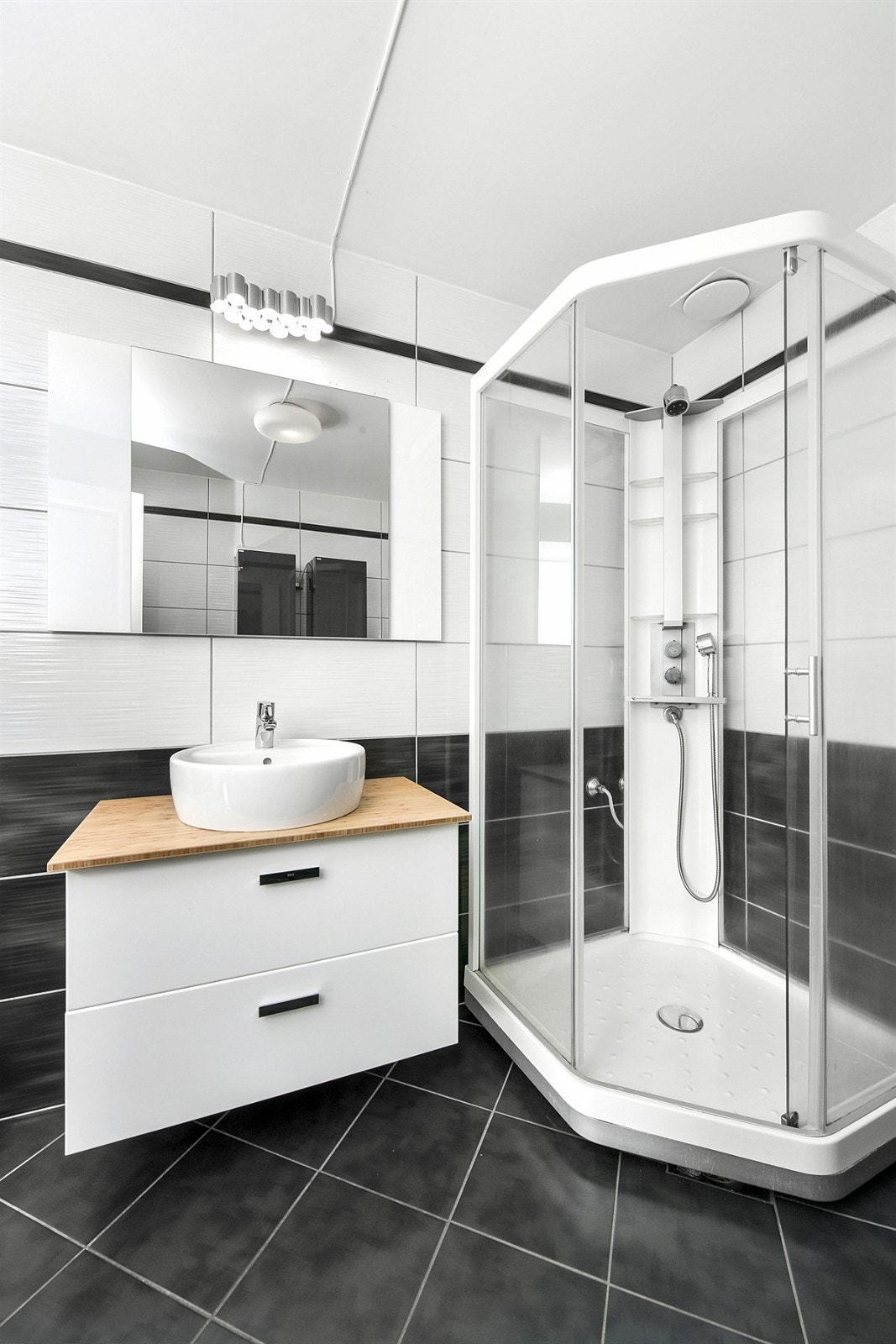 Badet er moderne med innredning fra 2017 som består av rund servant på heltre benkeplate, speil og belysning. Galleribilde