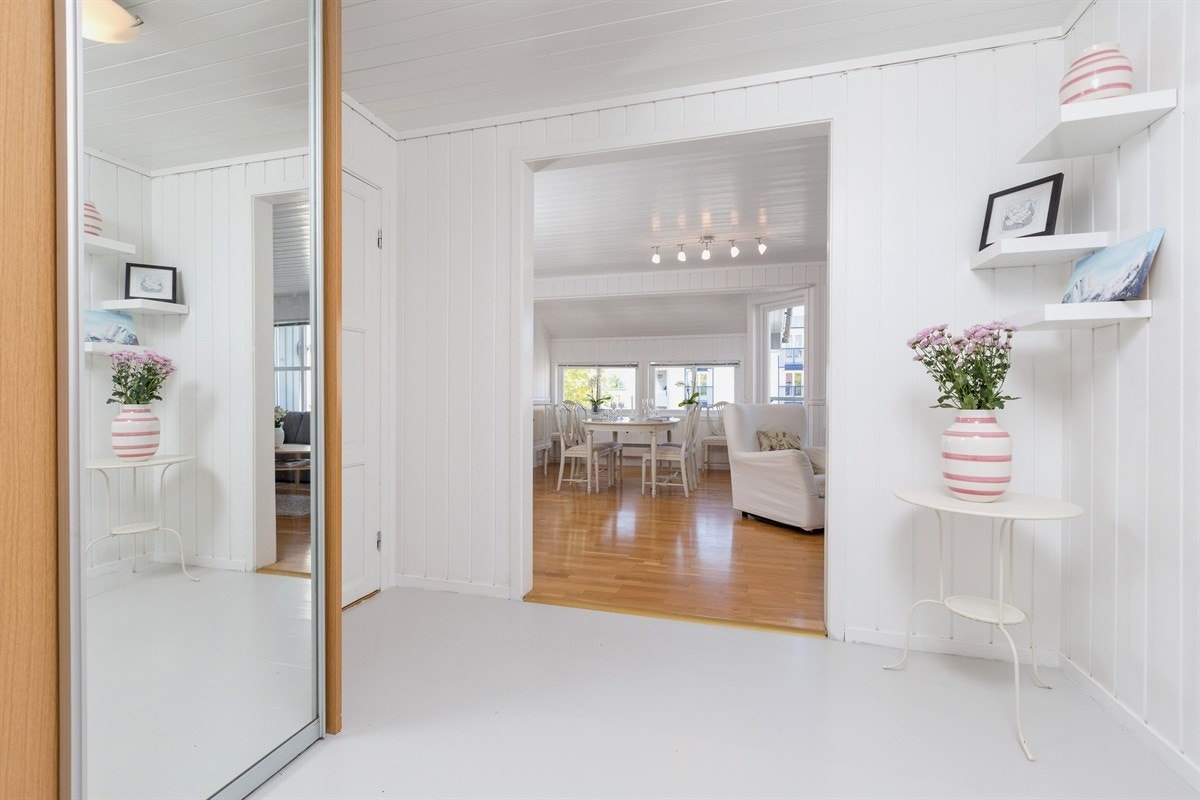 Med inngang fra bakkeplan ankommer man en lys og luftig entrè innredet med en romslig skyvedørsgarderobe med speil-skyvedør. Galleribilde