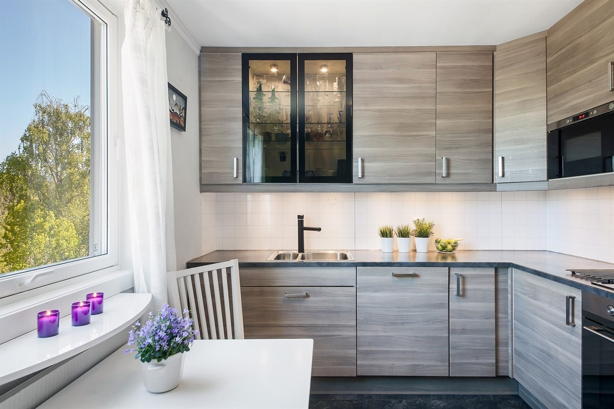 Videre er kjøkkenet utstyrt med integrerte hvitevarer og har induksjonstopp, stekeovn, oppvaskmaskin, kjøleskap og fryseskap Galleribilde