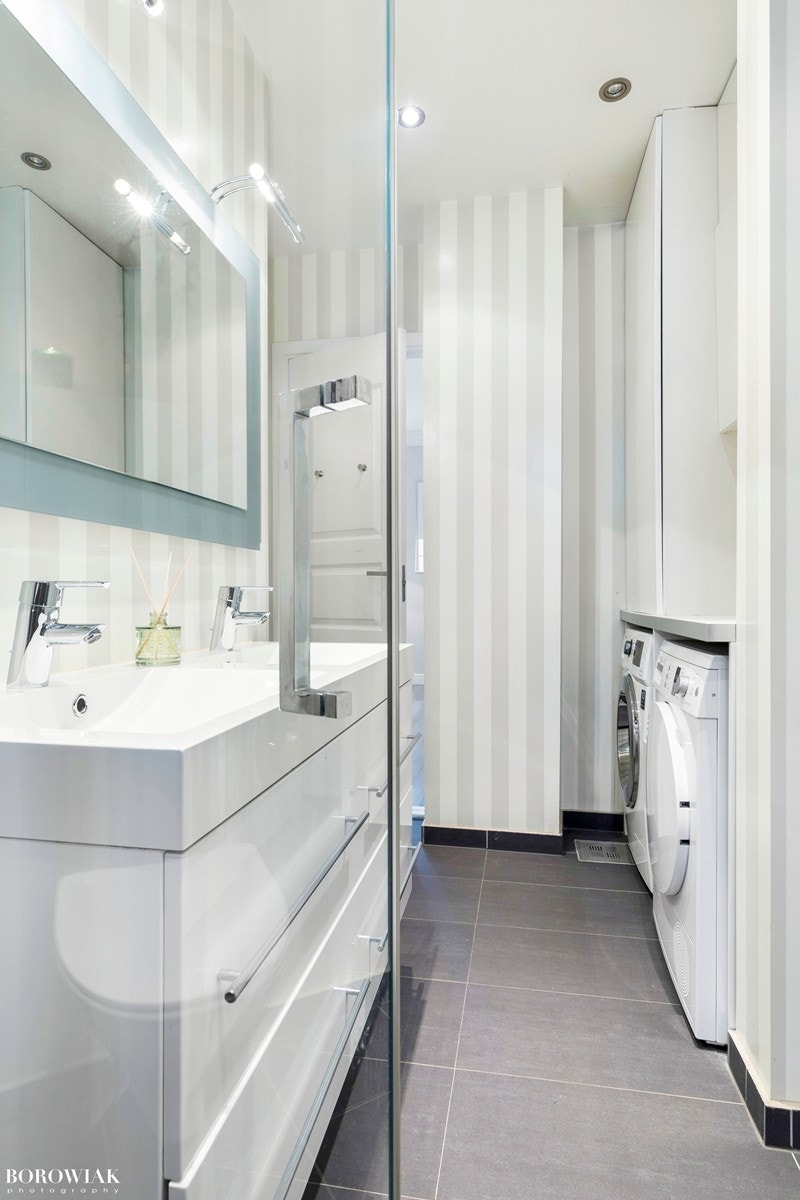 Badet er utstyrt med dobbel servant med underskap, vegghengt toalett og en plassbygd løsning med opplegg for både vaskemaskin og tørketrommel. Galleribilde